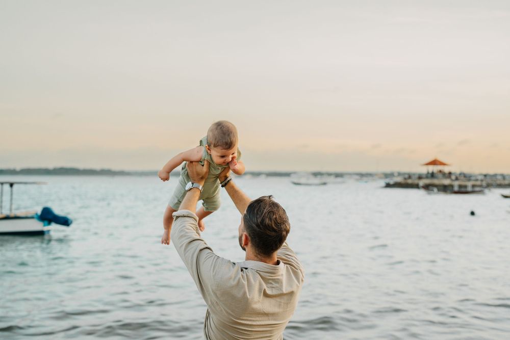 Family enjoying a beautiful sunset together at the beach with ocean views.