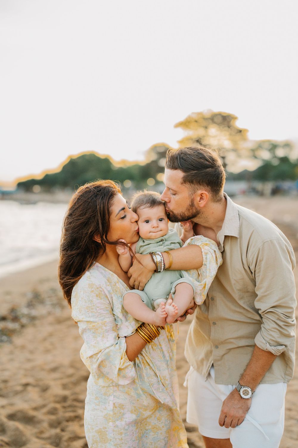 Family sharing loving embraces and kisses on a sunny beach.