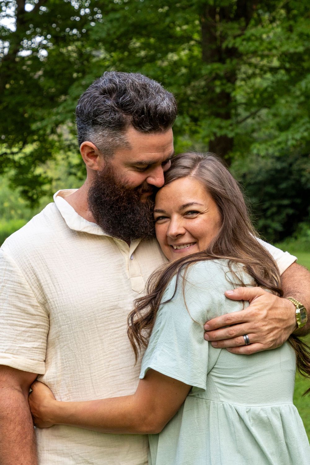 A wife hugging her husband cuddled in close