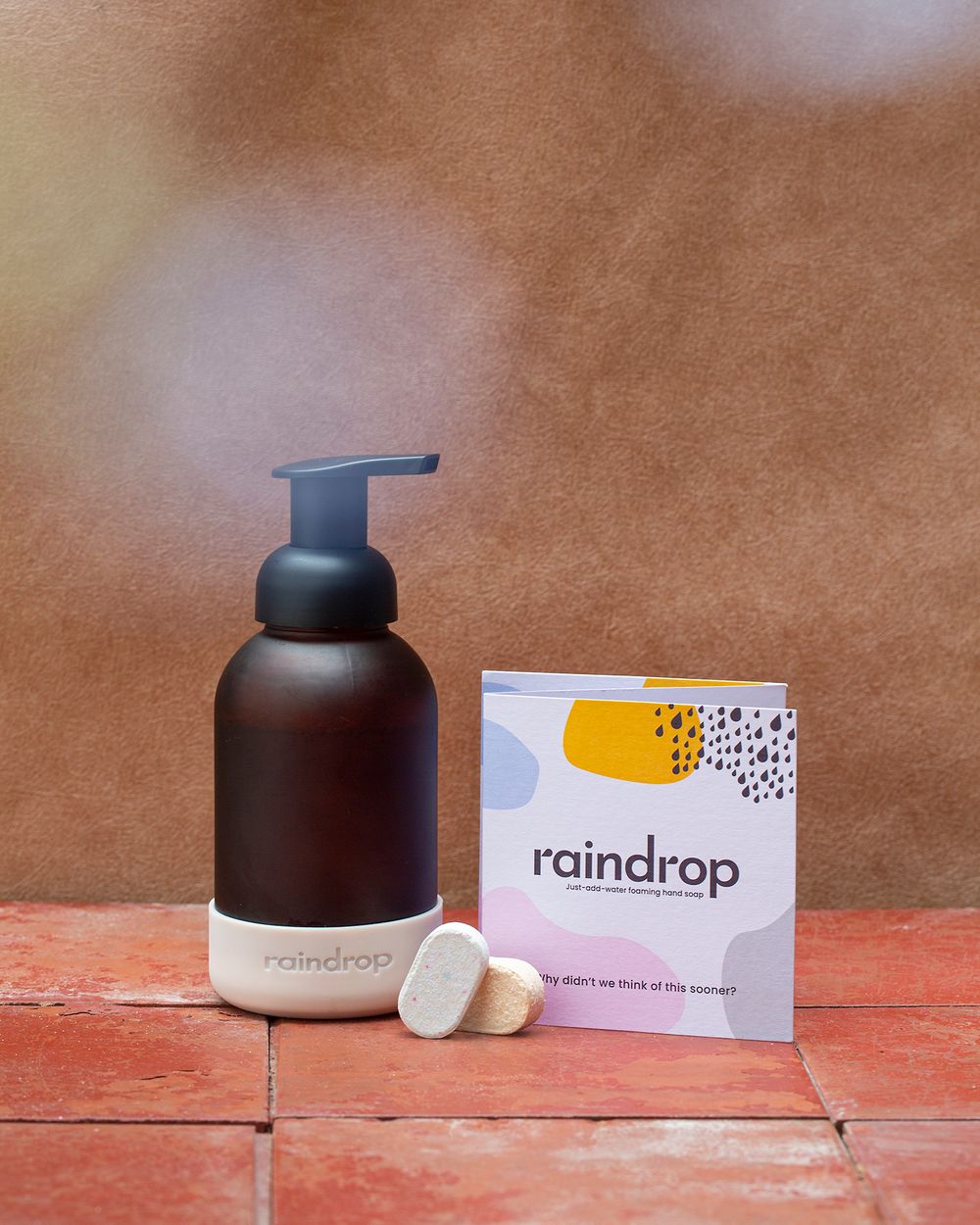 Modern cosmetic products with Raindrop branding on wooden surface.