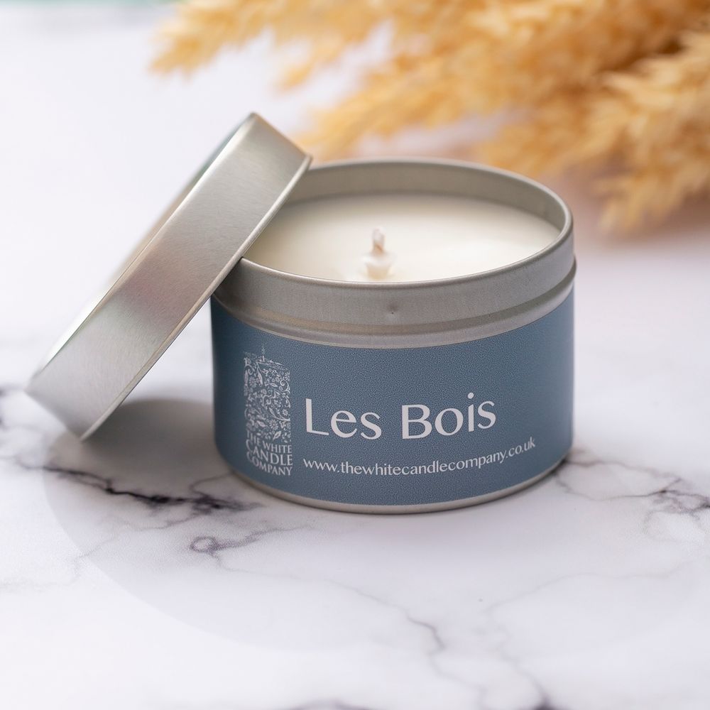 Les Bois scented candle tin with silver lid on marble surface.