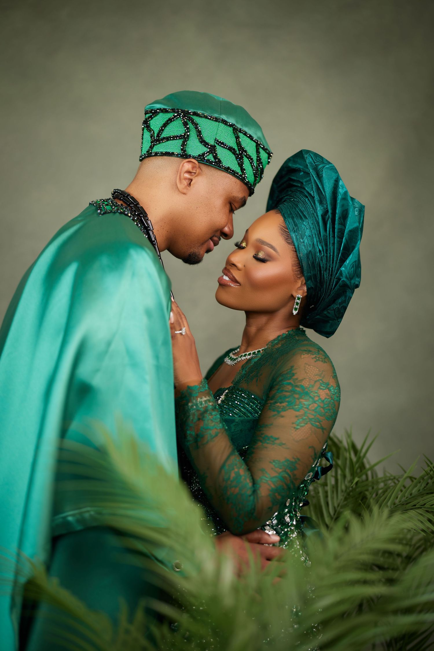 A romantic couple in matching turquoise traditional attire share tender moments through a series of intimate portraits.