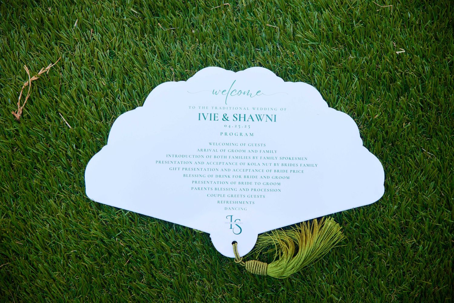 White wedding invitations arranged neatly on green grass with a natural garden backdrop creates an elegant composition.