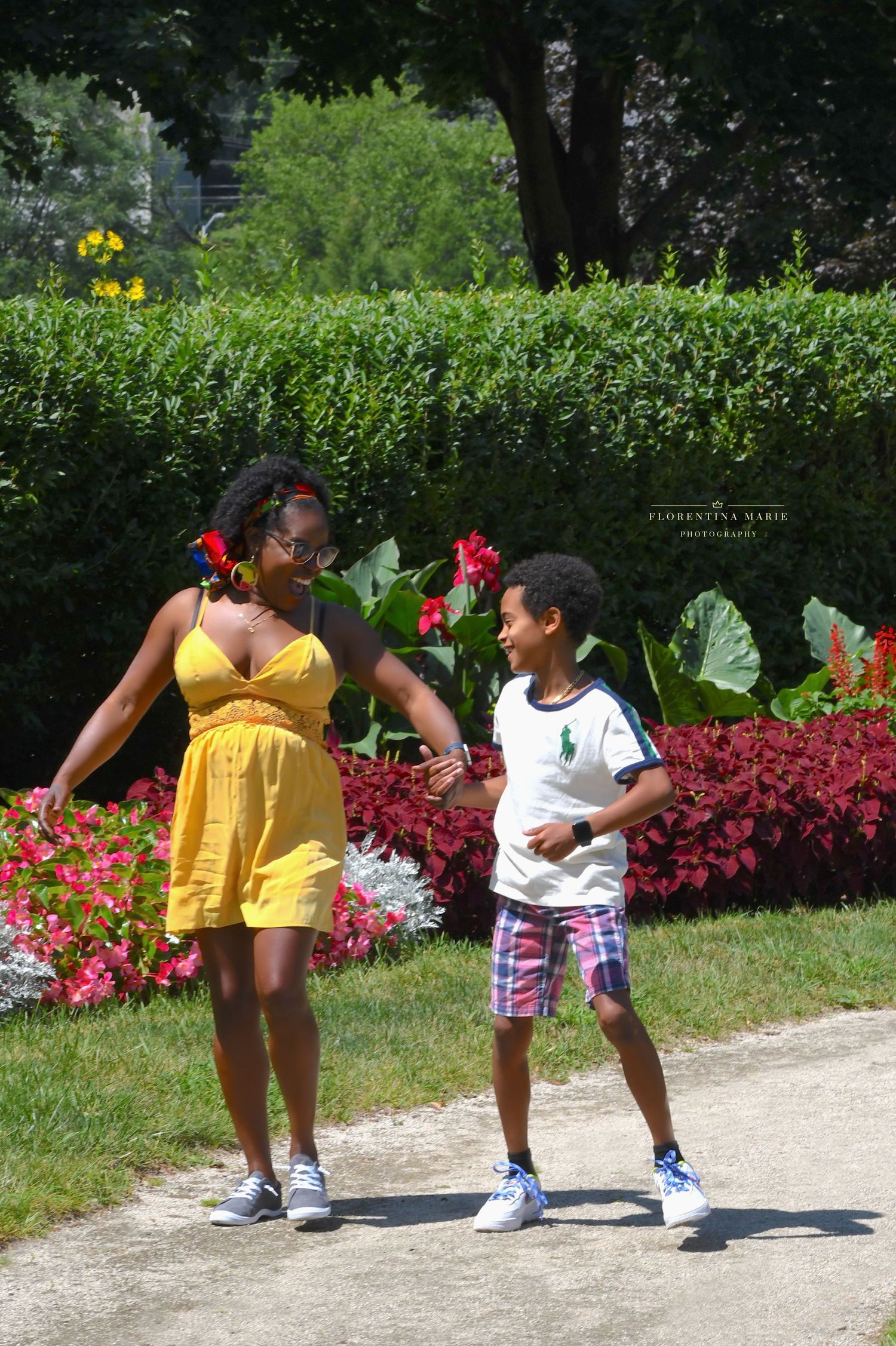 A cheerful moment captured in a garden with yellow dress and bright flowers.