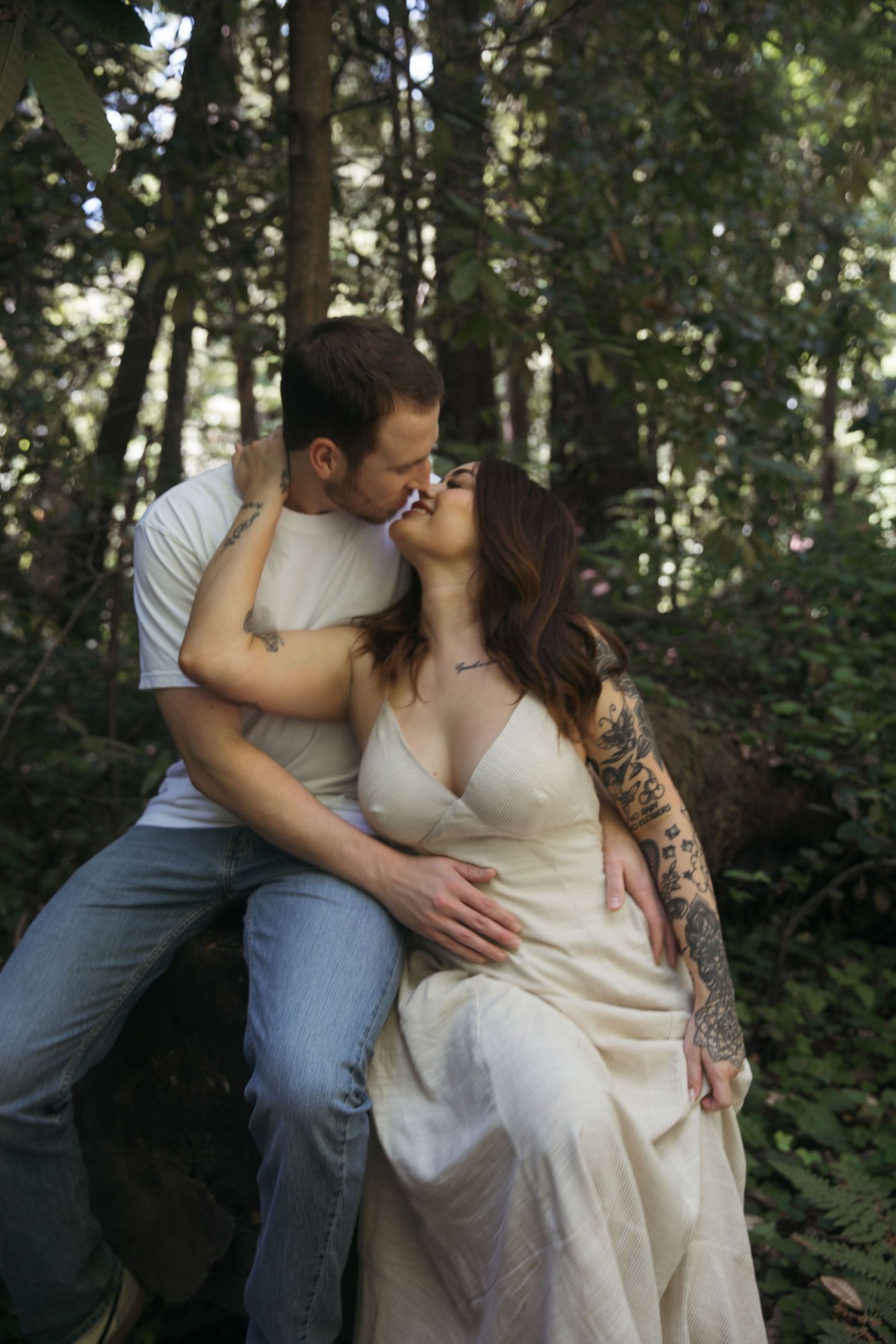 A romantic forest photoshoot featuring a couple in elegant attire.