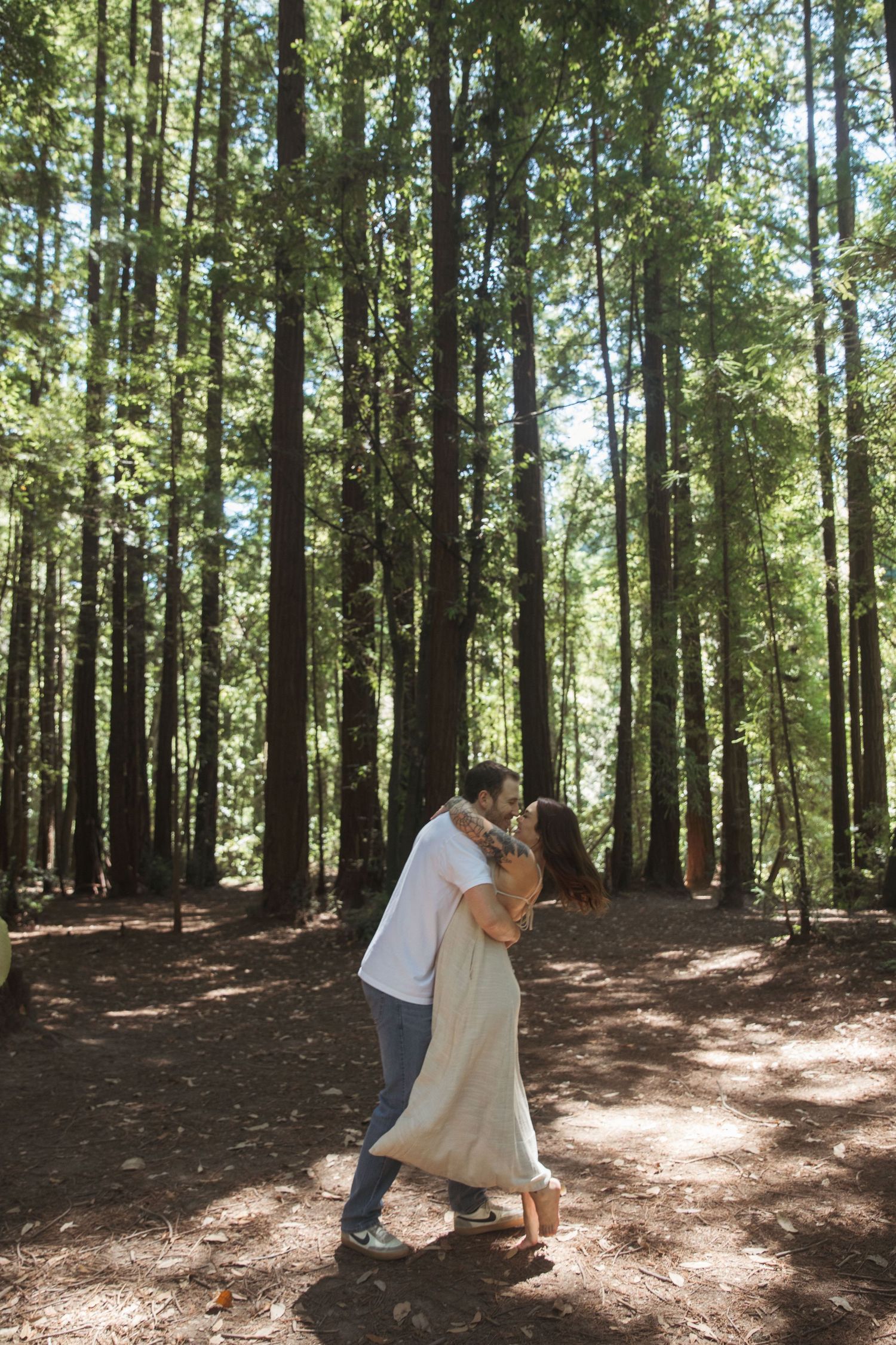 A romantic dance between two people in a majestic forest setting.