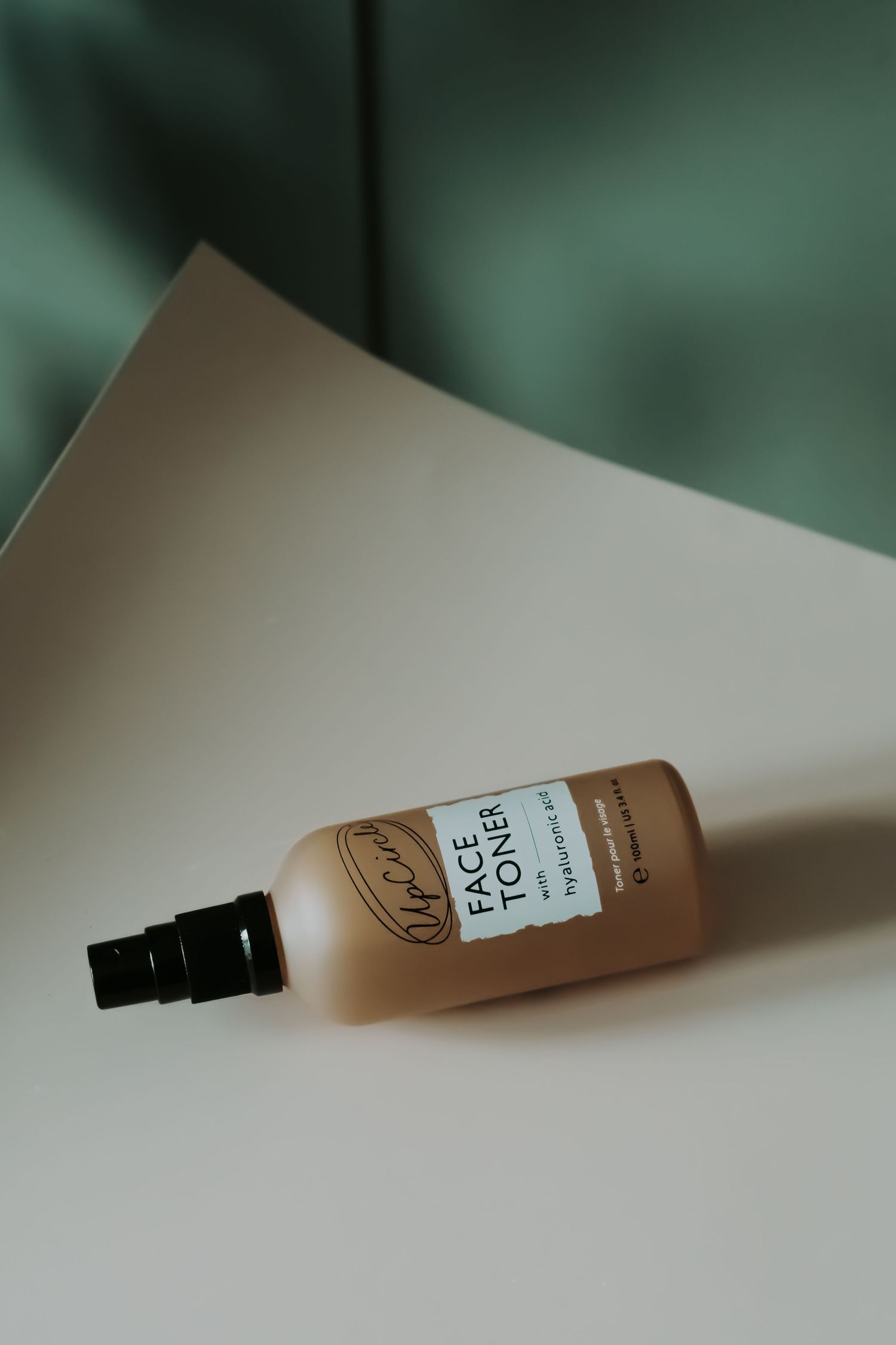 studio photo of a diffuser called Delicate Bloom with a single flower and part of a rock