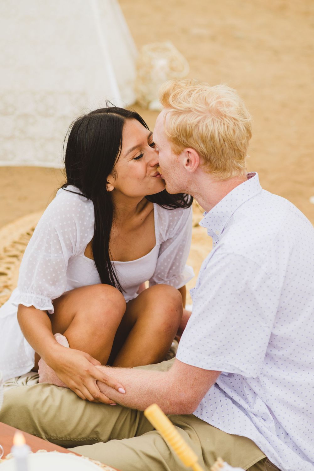 A couple takes their engagement photos at Sunset Cliffs as they embrace and share a kiss during sunset.
