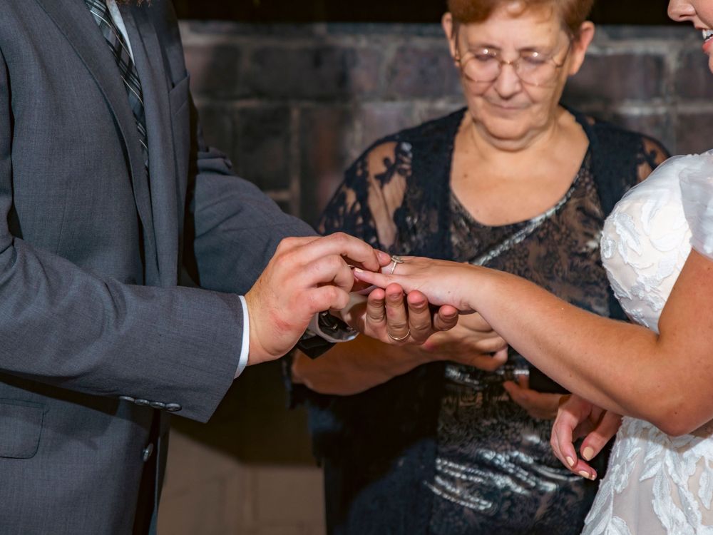 A close-up shot of hands exchanging wedding rings during a ceremony.