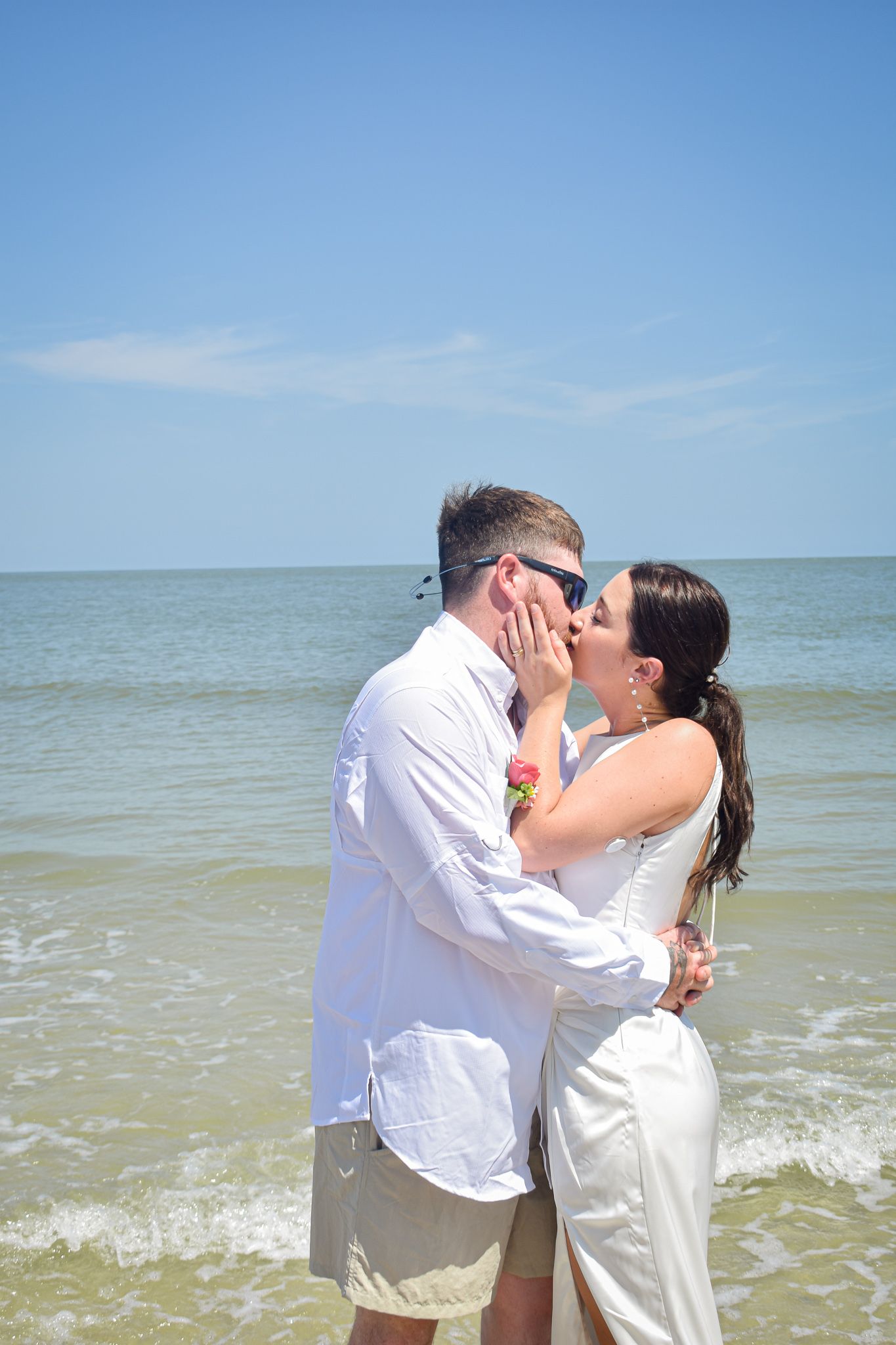 A couple shares an intimate moment during their beach wedding ceremony.