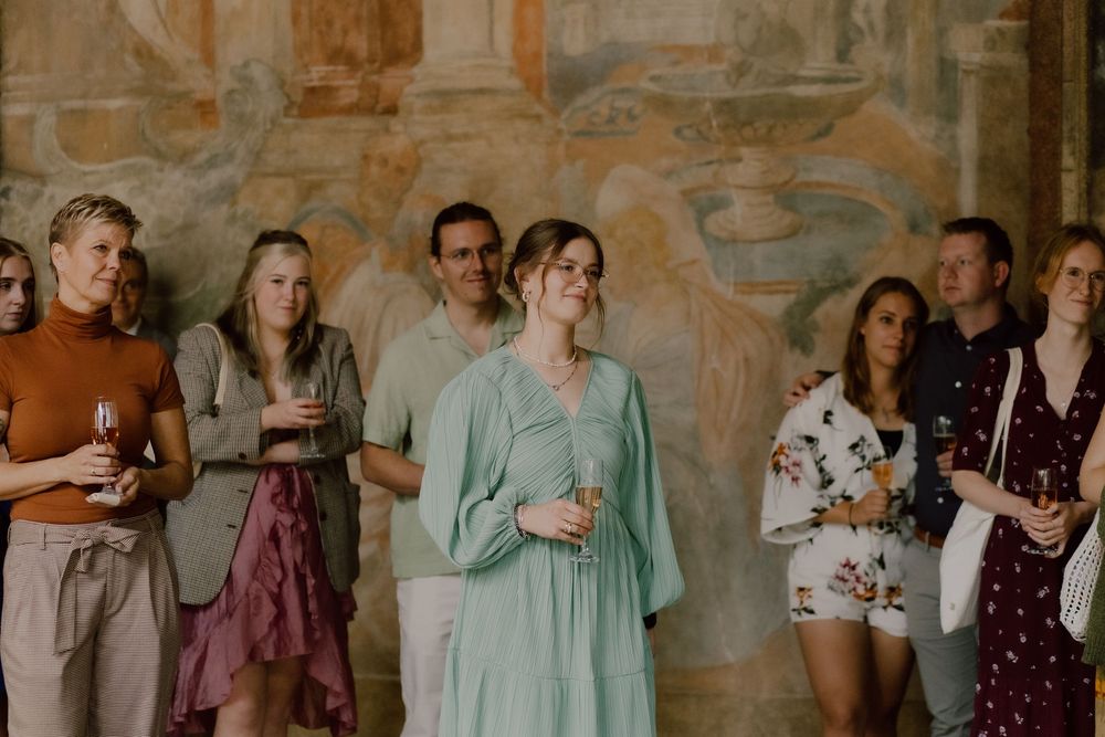 Wedding guests gathered in a rustic stone-walled venue during a celebration.