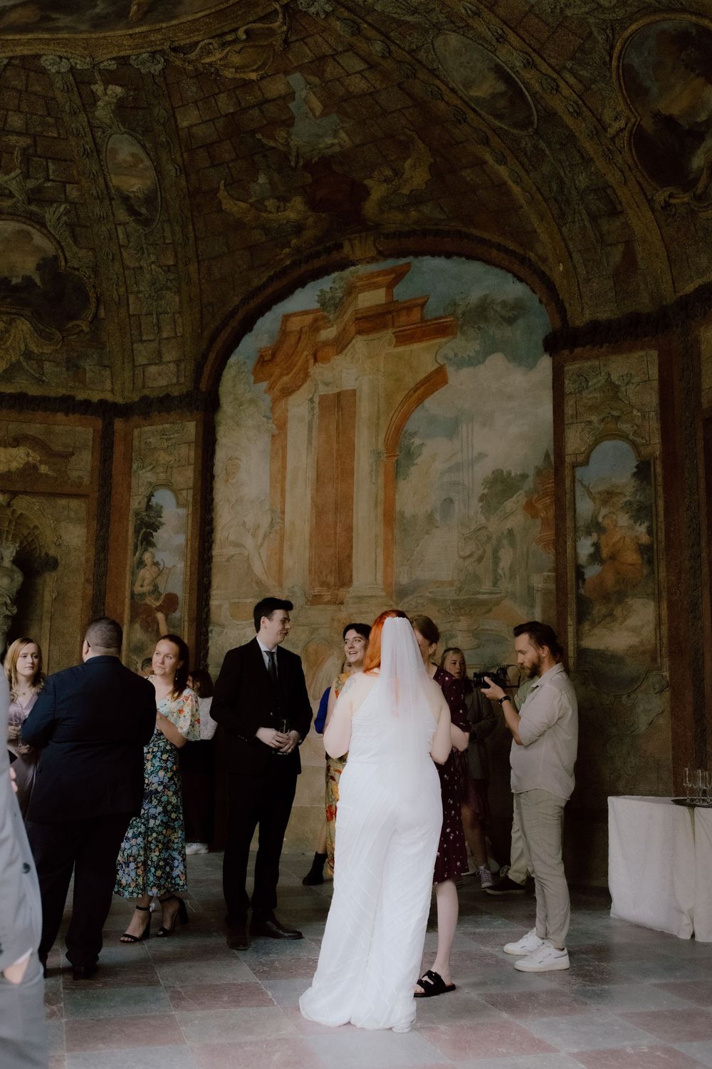 Wedding celebration in a grand historic venue with vaulted ceilings and archways.
