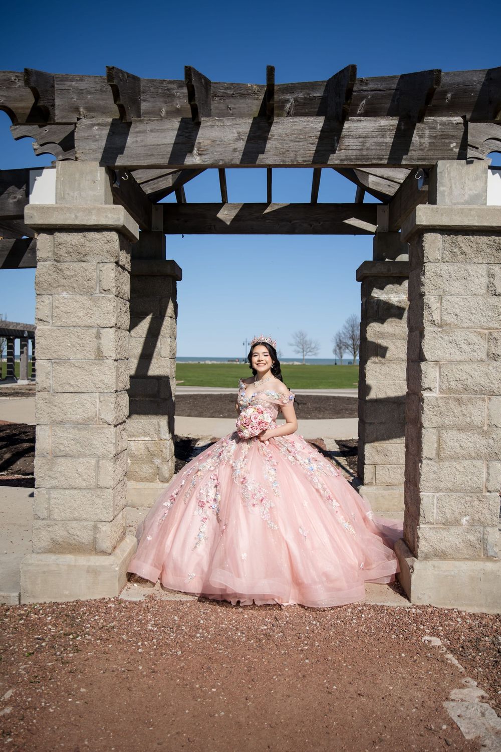 Anahí’s Quinceañera portrait under a garden pergola. Stunning pink XV gown photography at Independence Grove by Alex T Photography.