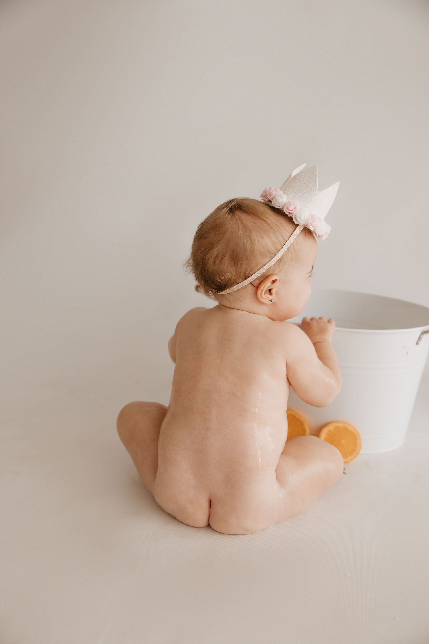Small child leaning over to taste chocolate cake with blue frosting on white cake stand.