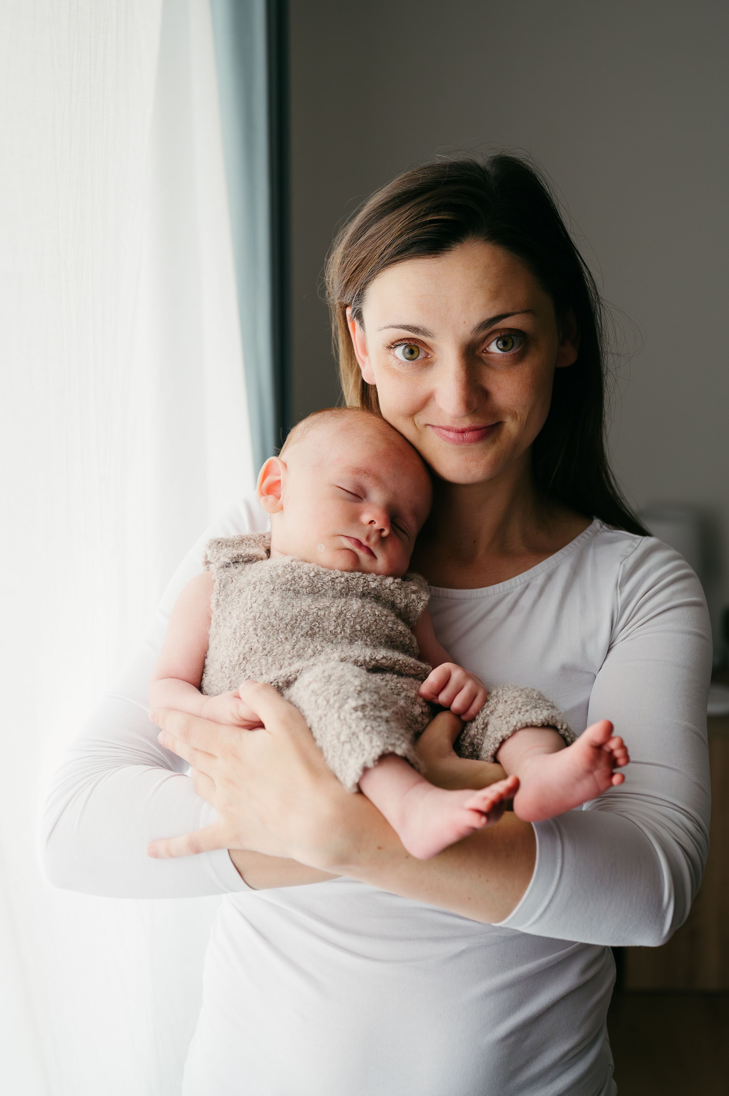 Maminka drží novorozené miminko v náručí při focení doma v Jičíně – přirozené newborn focení bez póz
