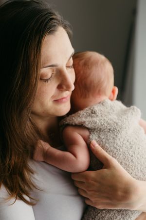 Maminka drží novorozené miminko v náručí při focení doma v Jičíně – přirozené newborn focení bez póz