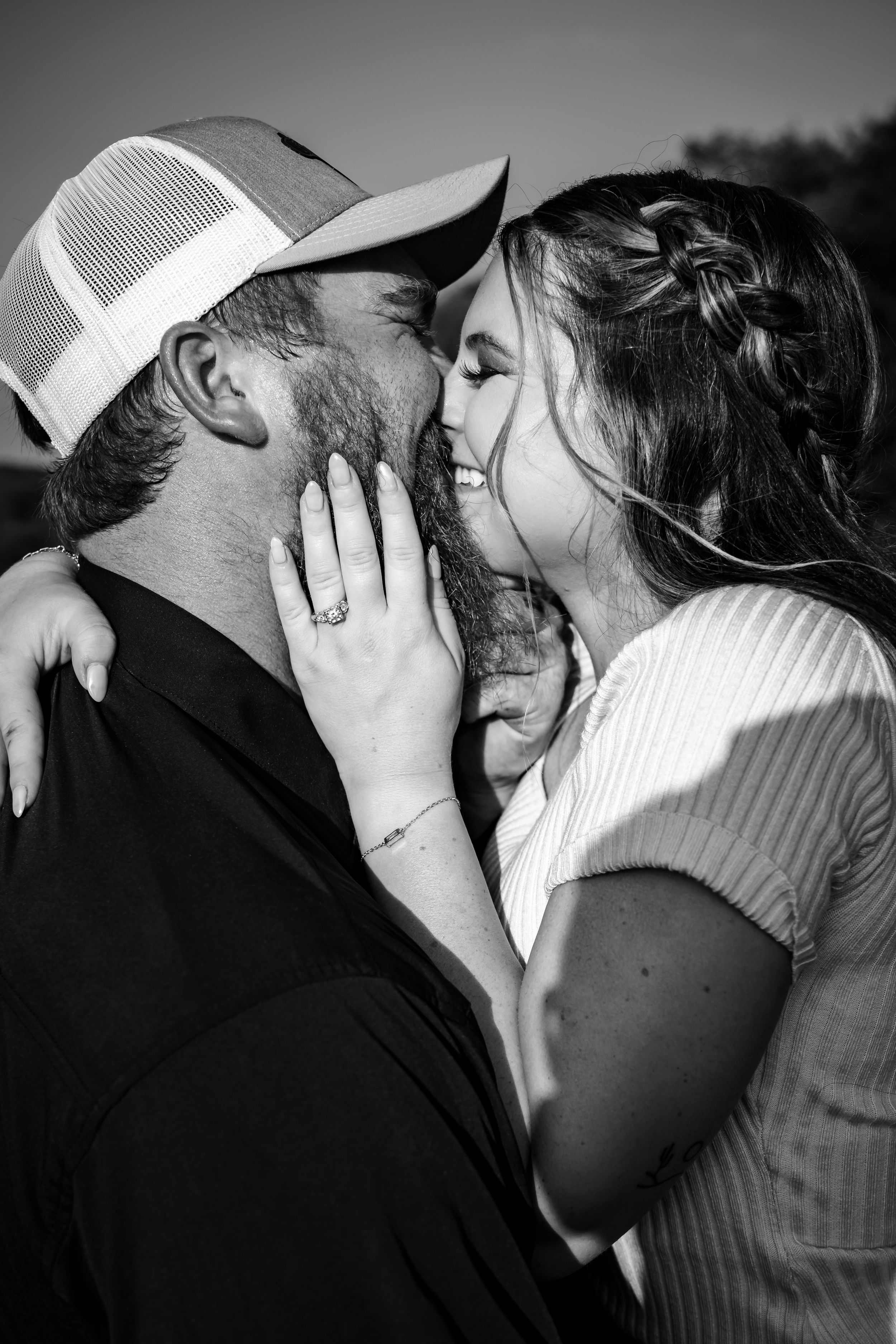 Black and white intimate portrait of couple sharing tender moment outdoors.