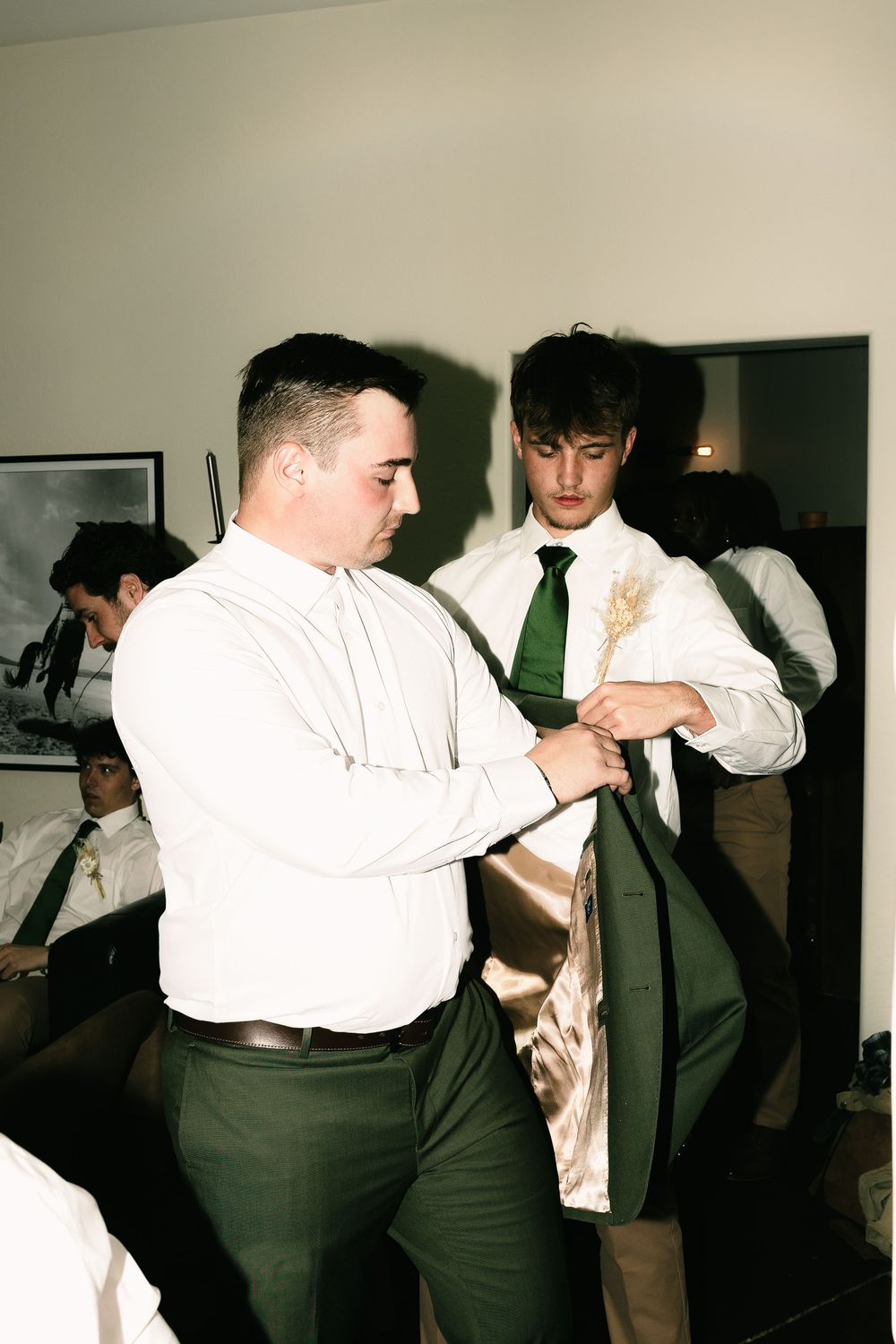 Groomsmen in white shirts and dark pants dance at a wedding reception.