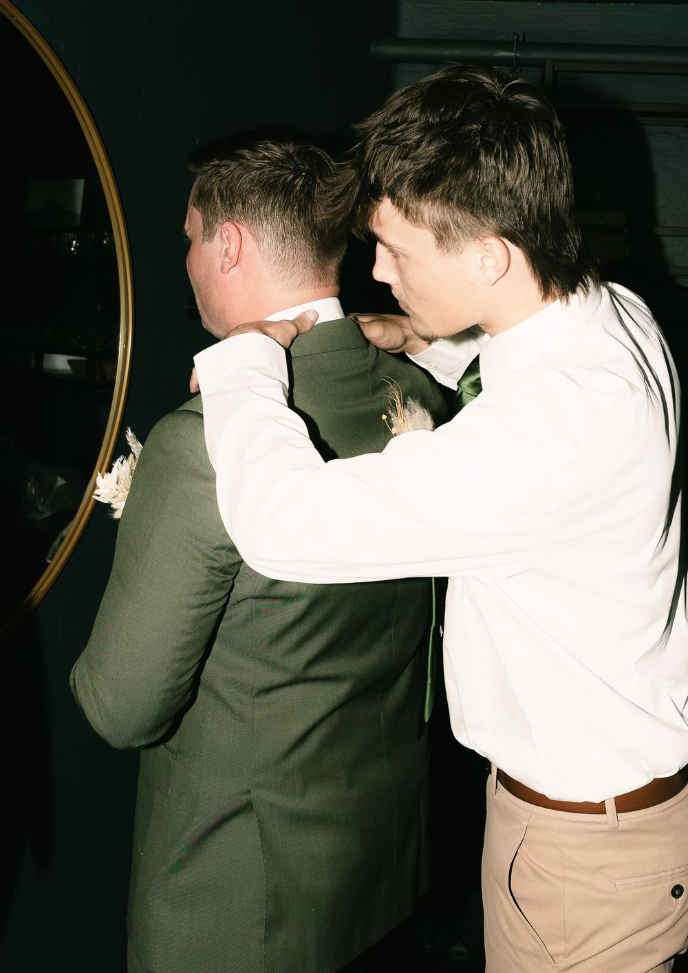 Wedding party members dance and celebrate in formal attire at an evening reception.