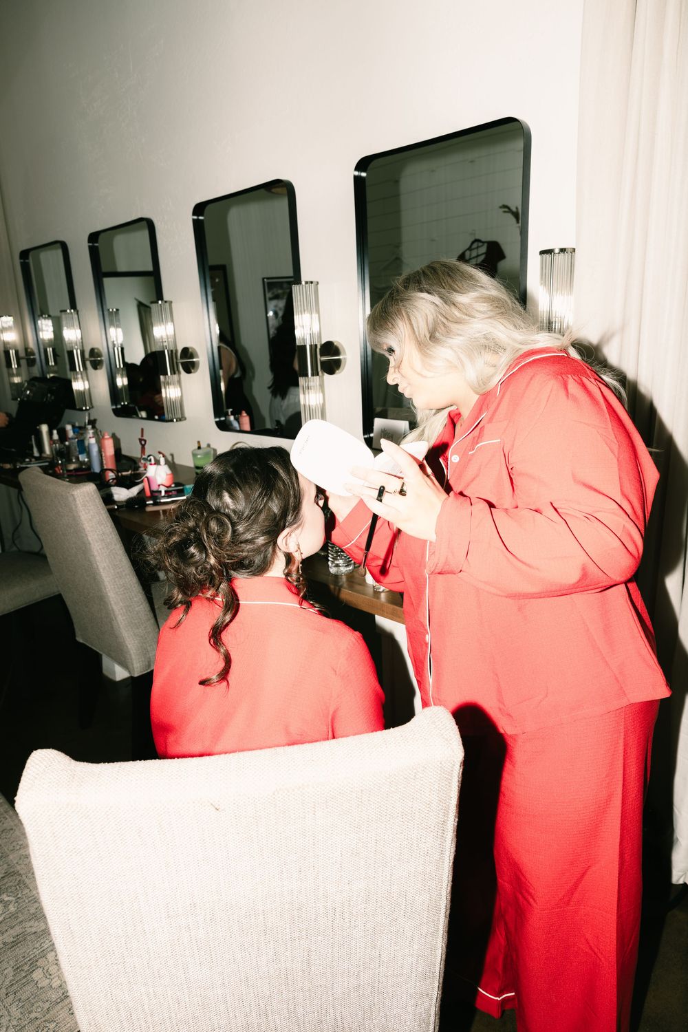 Hair styling session in a salon with mirrors and professional lighting.