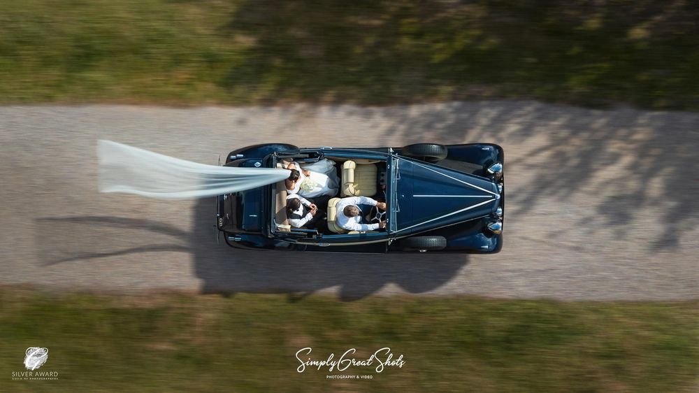 Redhouse Barn wedding photographer captures the bride and groom arriving in a classic wedding car.