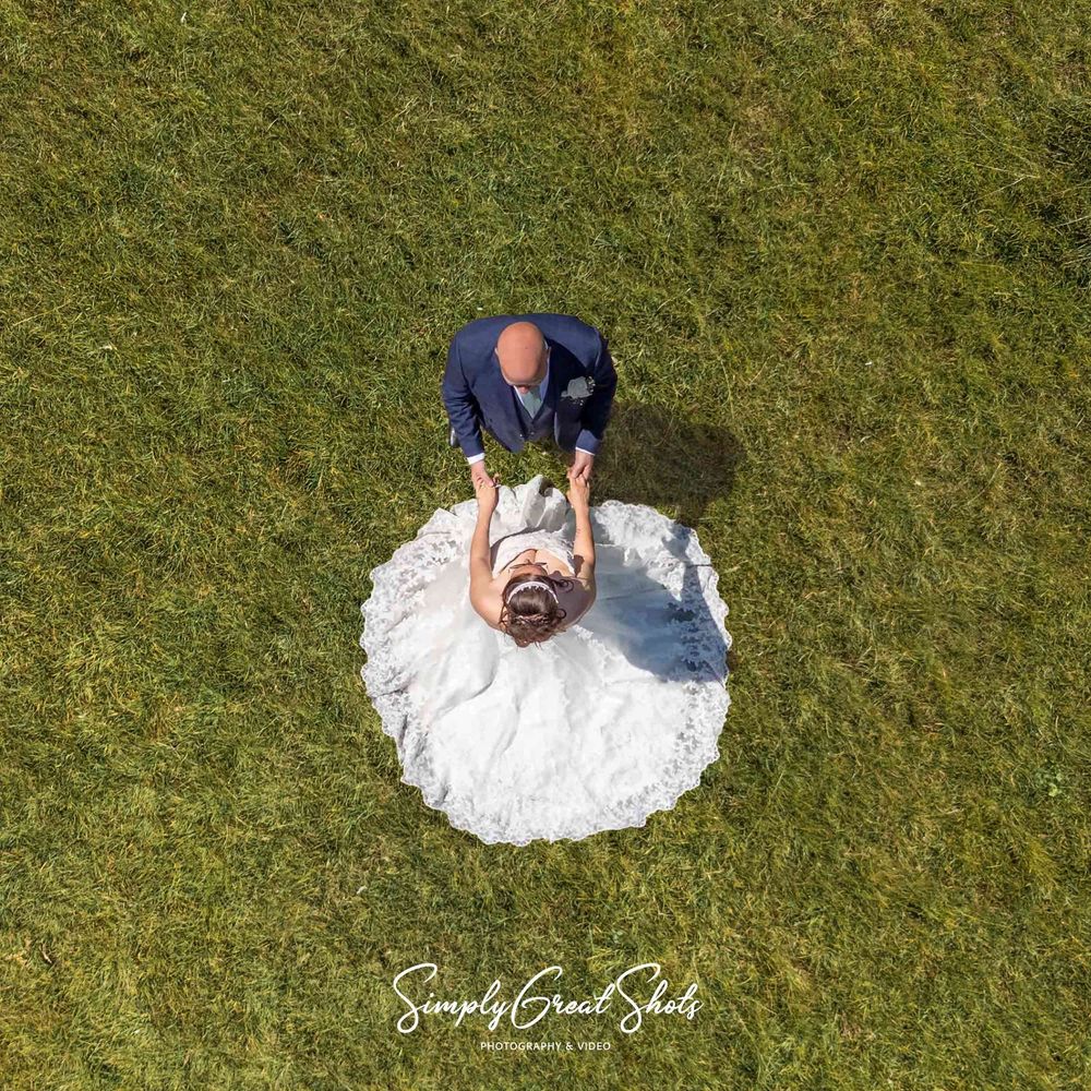 Captured from above by their wedding photographer William and Kerrie hold hands on a birght summers day - Simplygreatshots