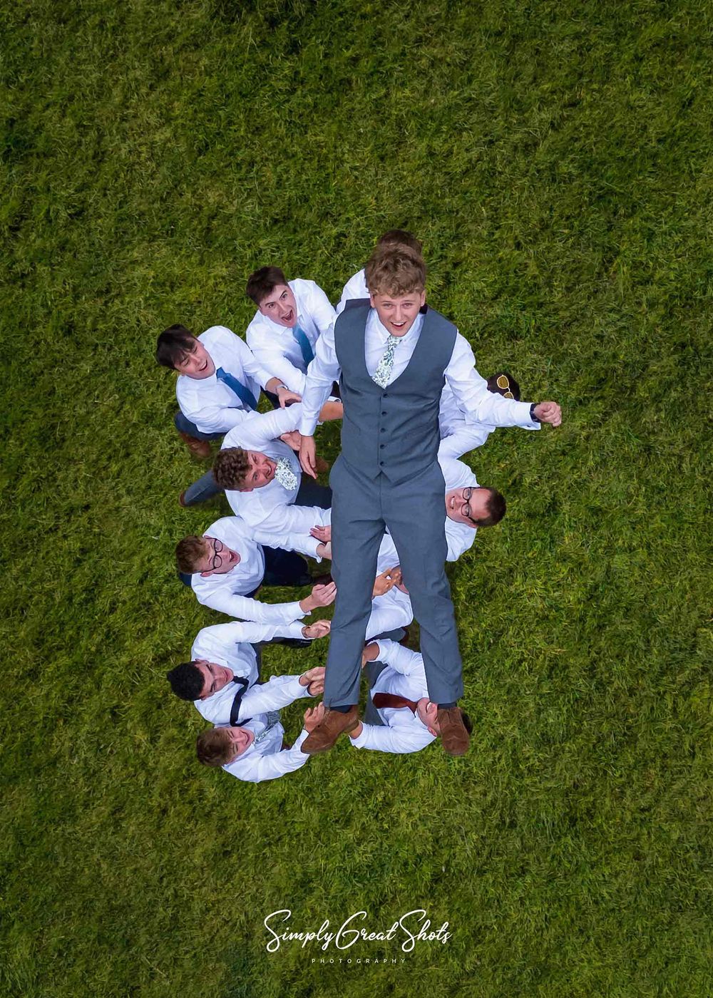 A wedding prographer captures the groom as he is thrown high in the air by his groomsmen. to celebrate getting married