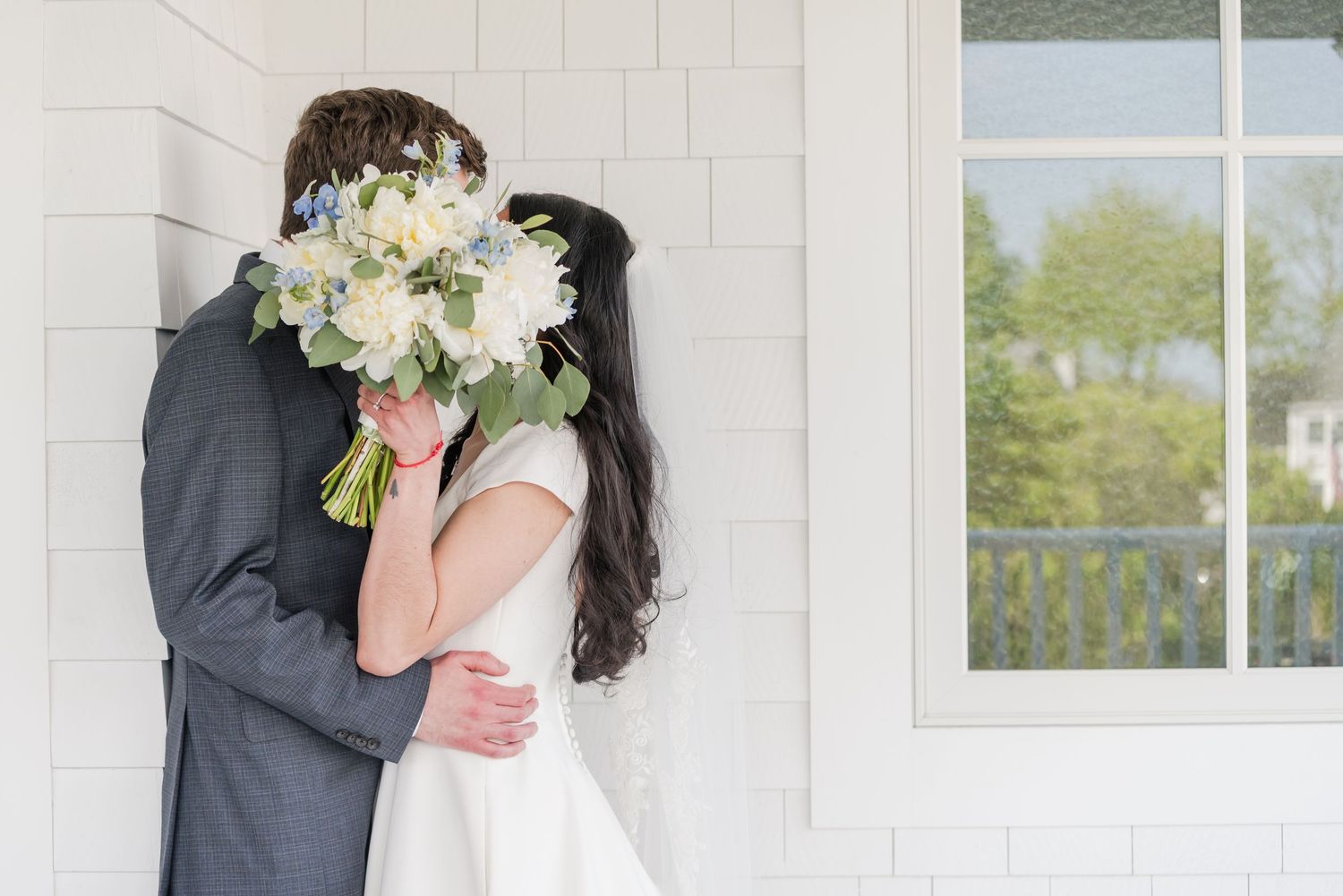 Romantic wedding portraits captured against white colonial architecture.