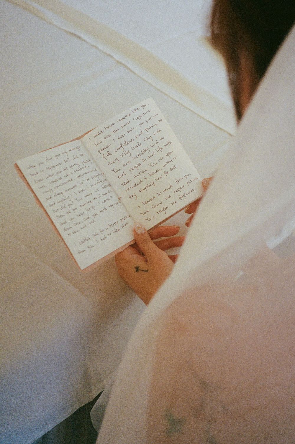 Handwritten notes in a journal viewed through soft, dreamy lighting.