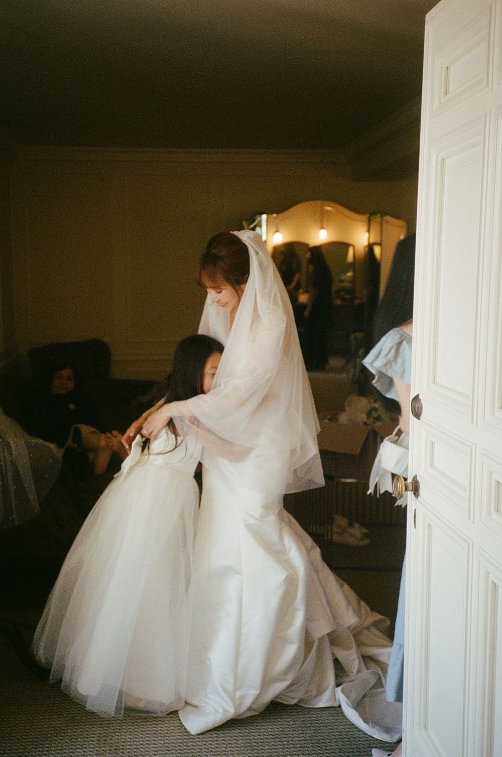 Wedding dress preparations with white gown and veil in an elegantly furnished room.