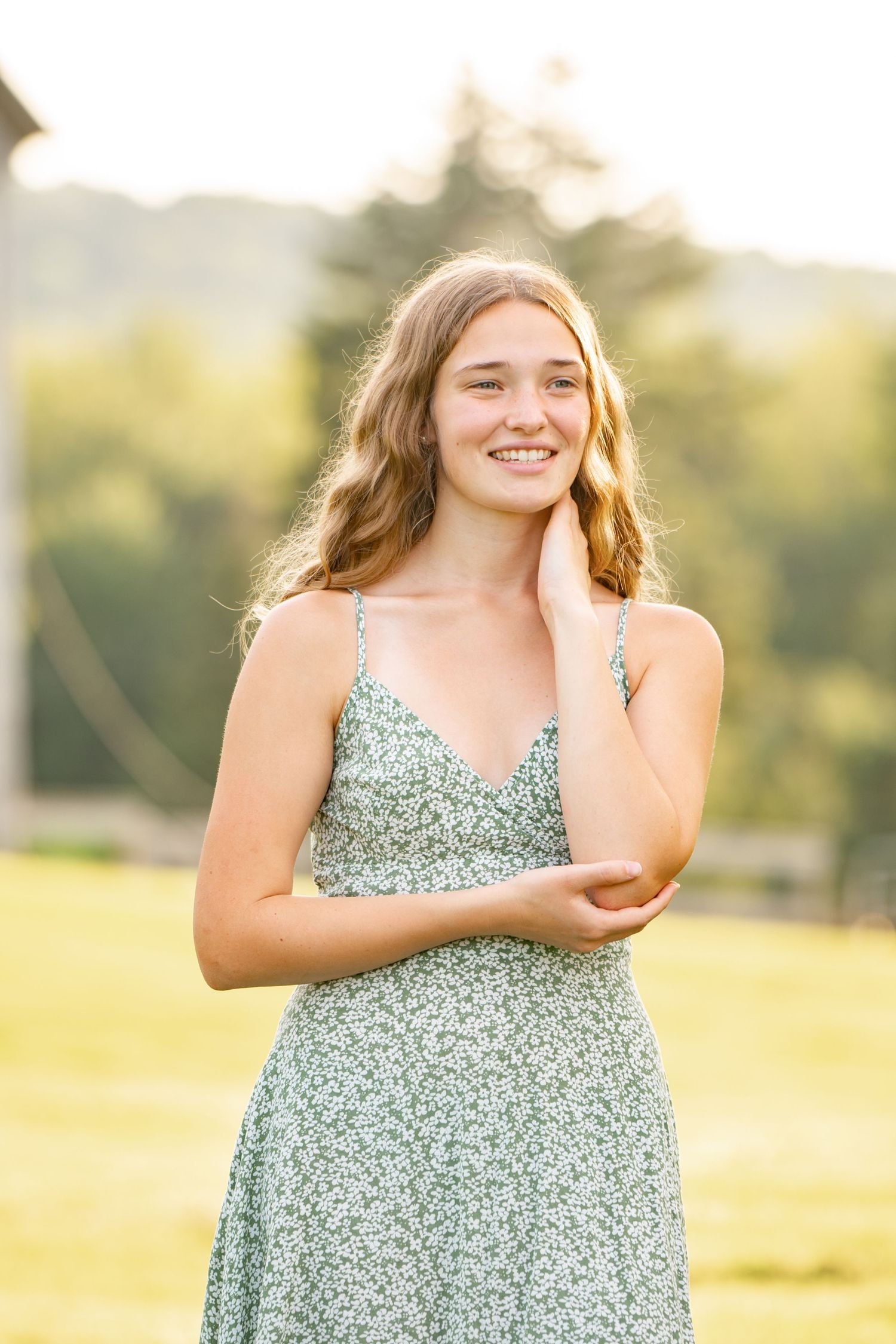 A series of natural light portraits in a green floral dress taken against a sunlit field during golden hour.