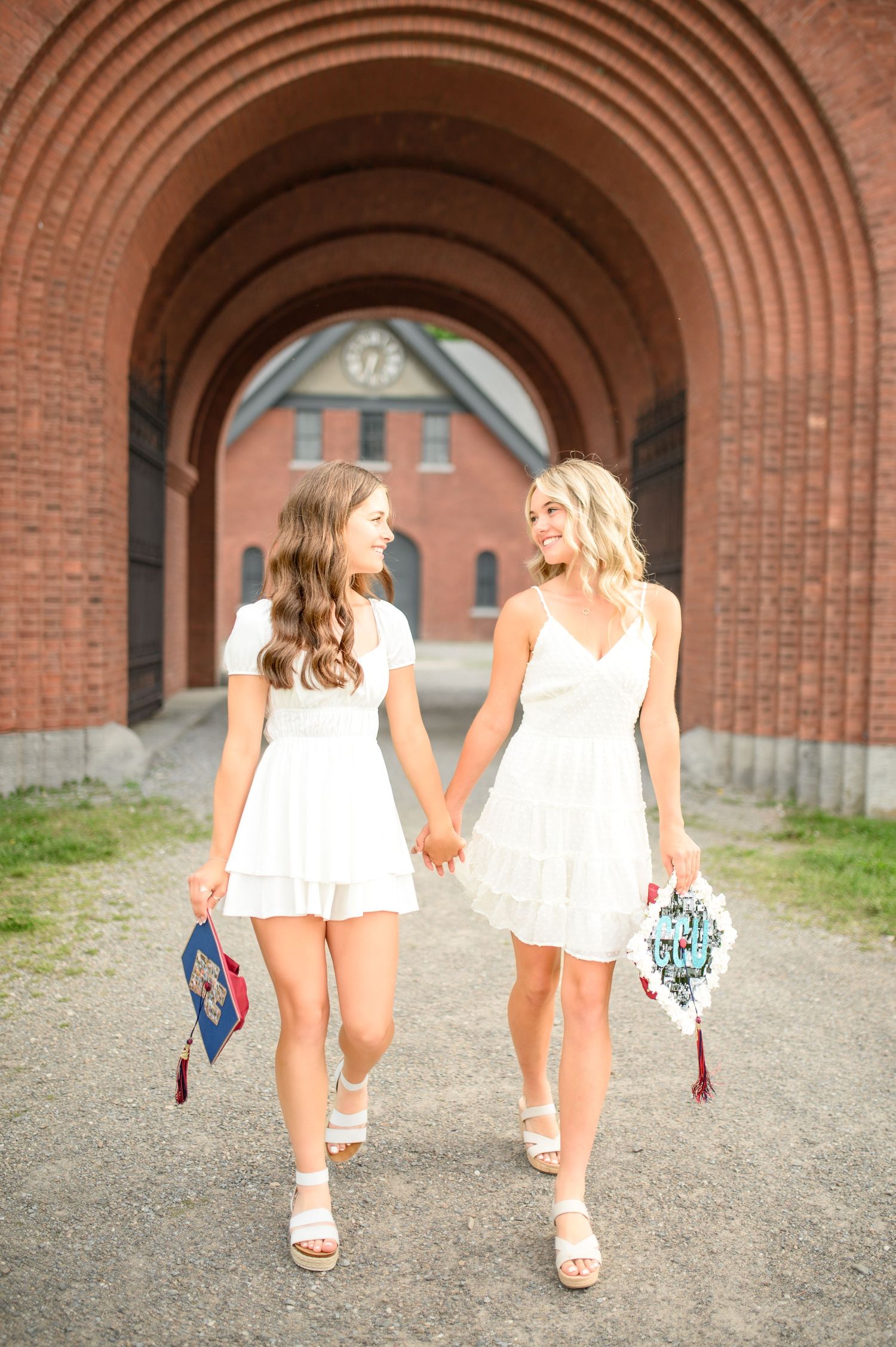 Two friends in white dresses walking together under brick archways at sunset, shown from multiple angles in progression.