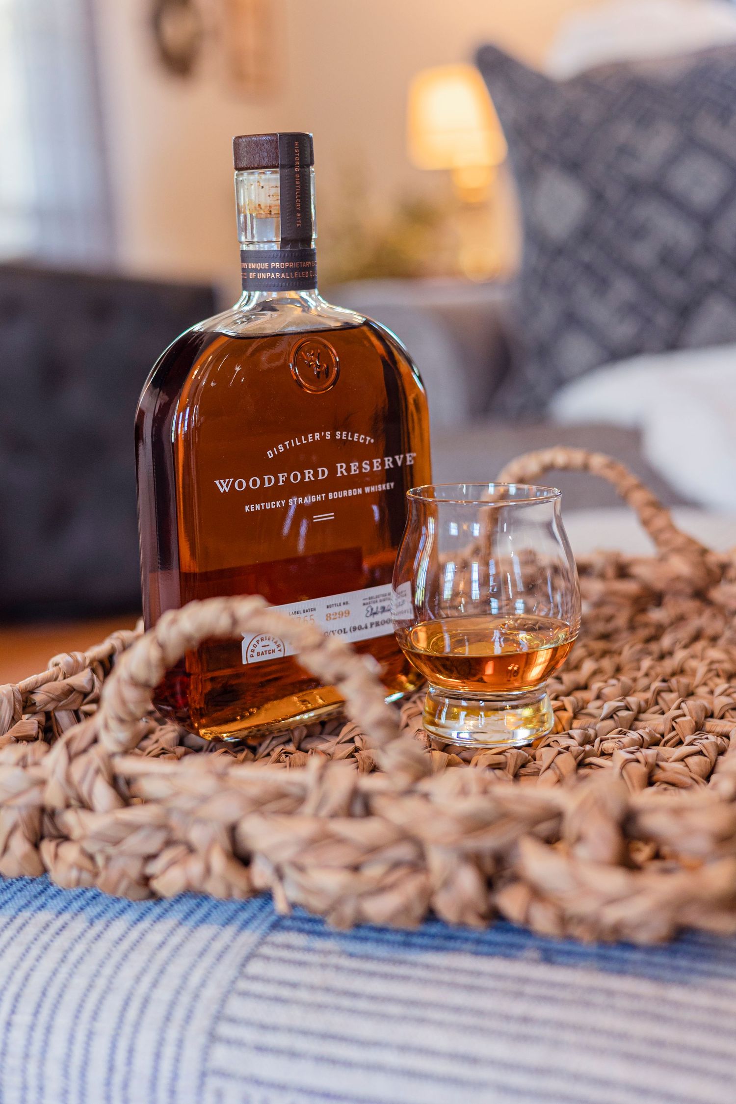 Bourbon bottles arranged on a textured surface with glasses and ambient lighting.