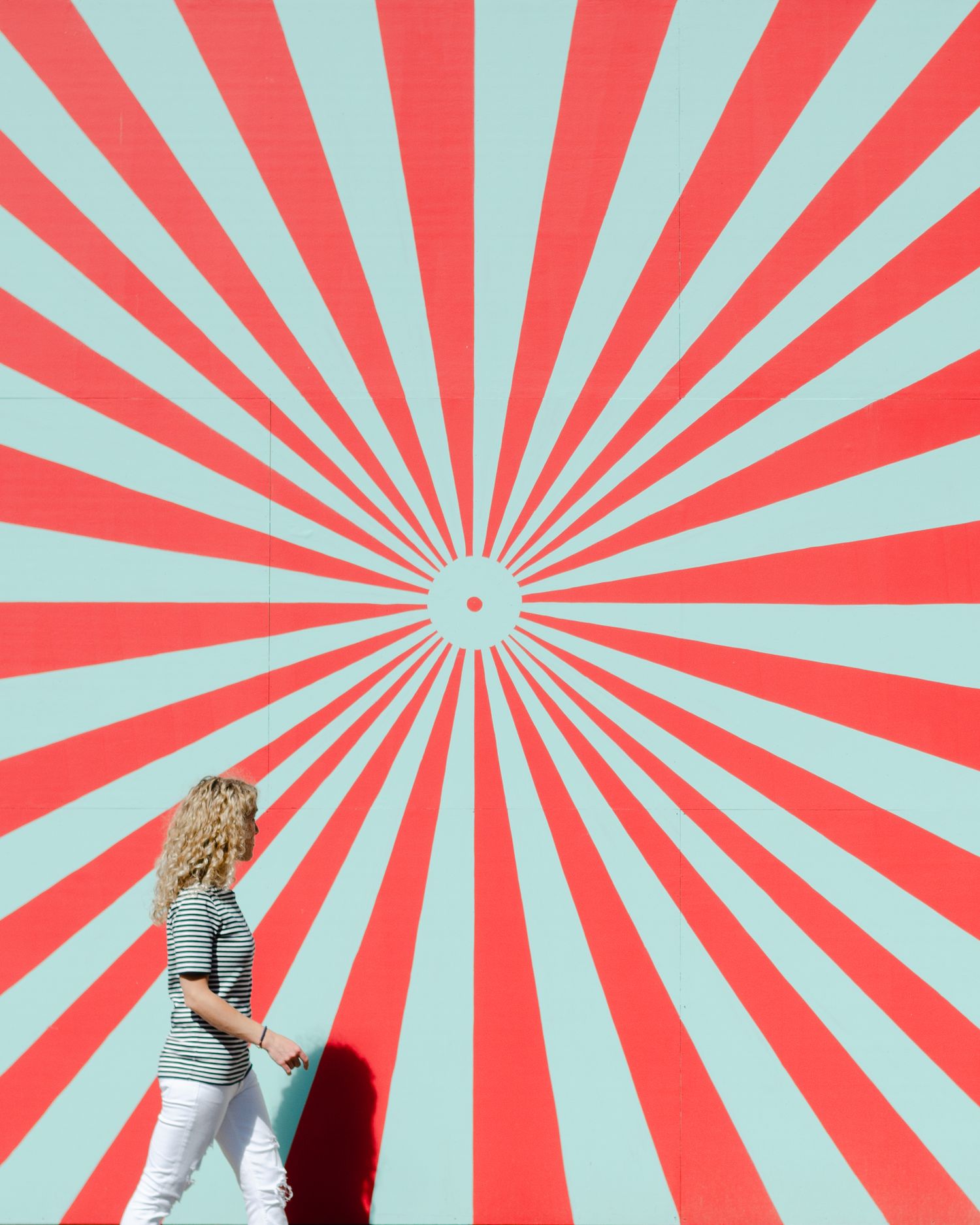 Orange County lifestyle photographer Kasha Gage walking along abstract background pattern with red and blue light rays.