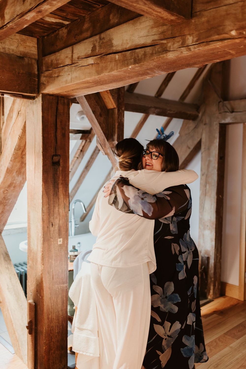 Rustic wooden beam interior room with natural lighting and wedding preparations underway.