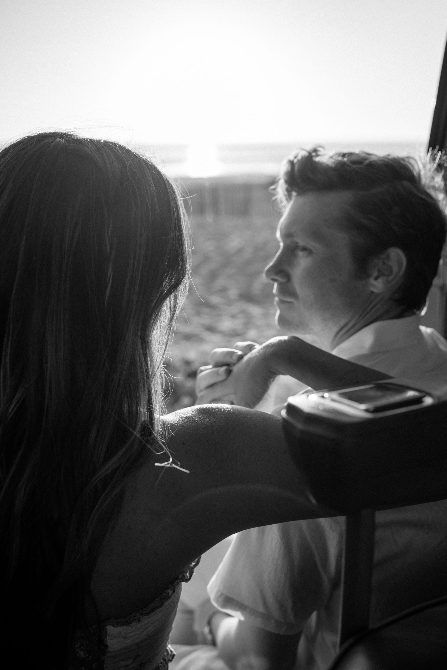 A series of romantic black and white profile silhouettes showing an intimate couple sitting together against bright backlighting.