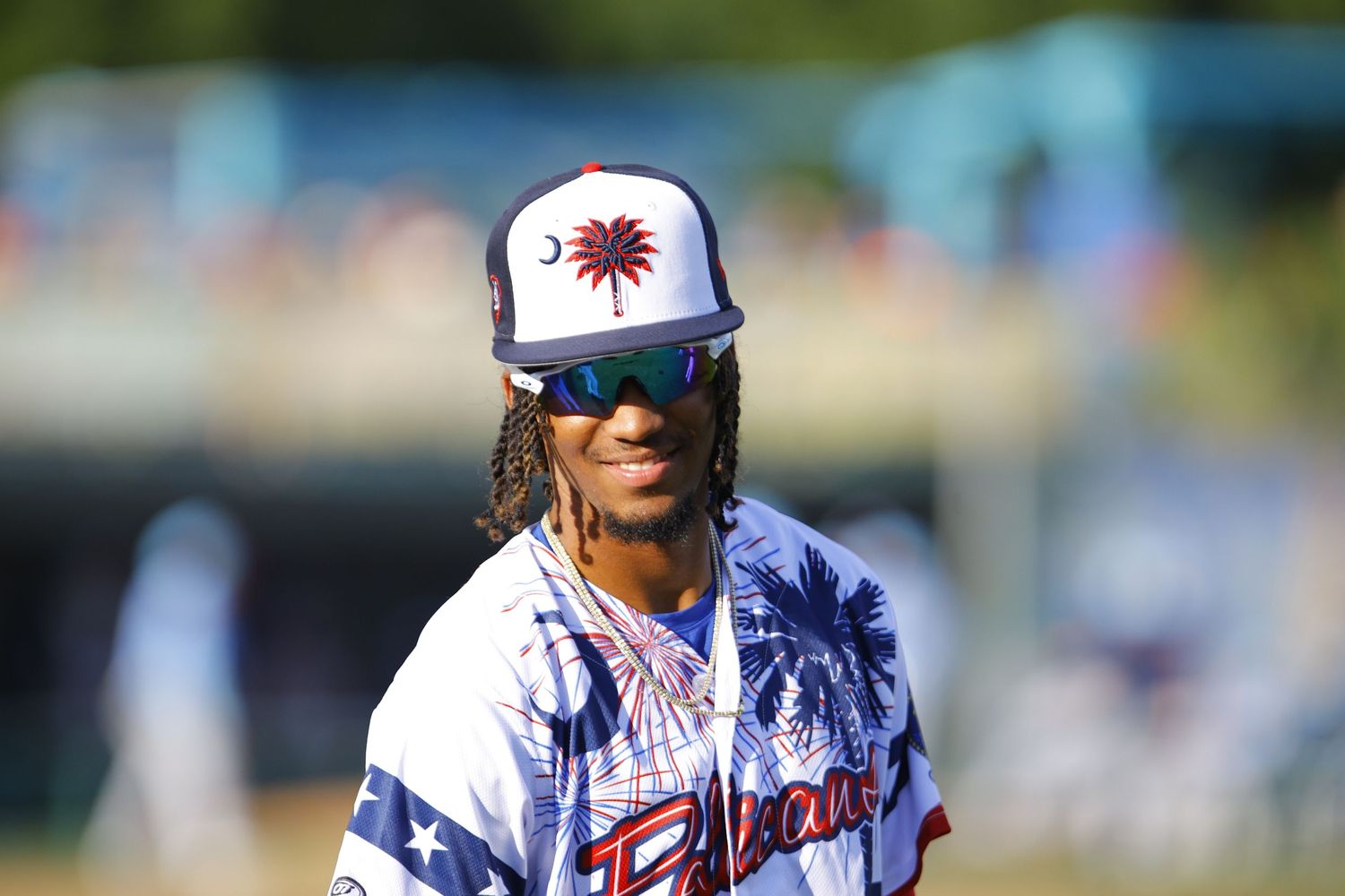 Baseball player wearing number 22 celebrates by raising his arm while running on the baseball field during a game.
