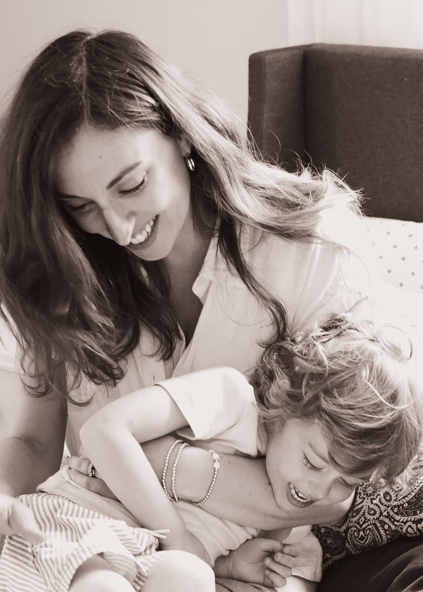 Black and white portrait of a candid tender moment of laughter and joy between two people on a couch.