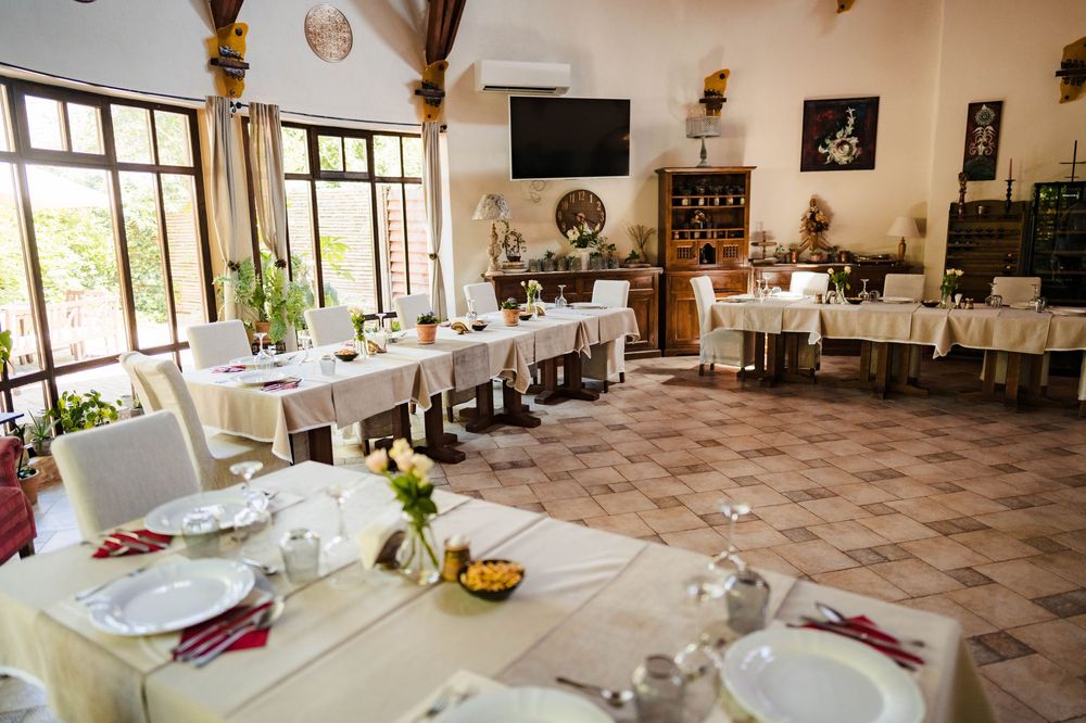 An elegant reception hall set up with round tables and chairs for a wedding celebration.