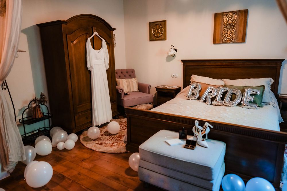 Wedding preparation room with dark wooden furniture and white balloon decorations.