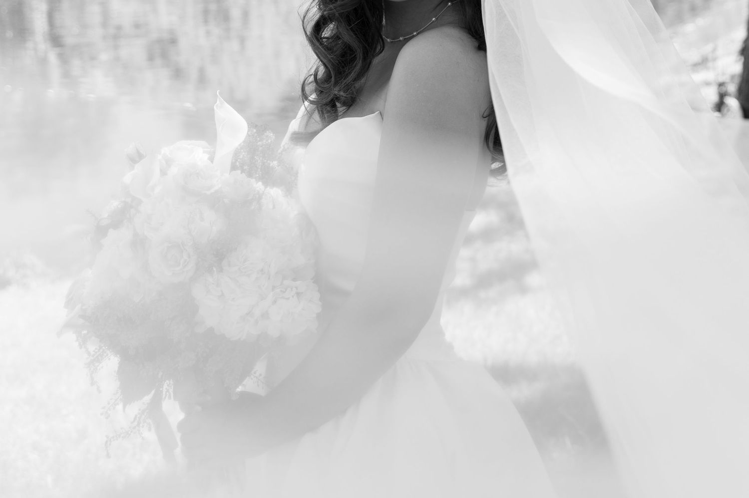 An image of a wedding vow book surrounded by a bouquet, perfume, eucalyptus leaves, ribbon, a ring box with rings, and shoes for a wedding.
