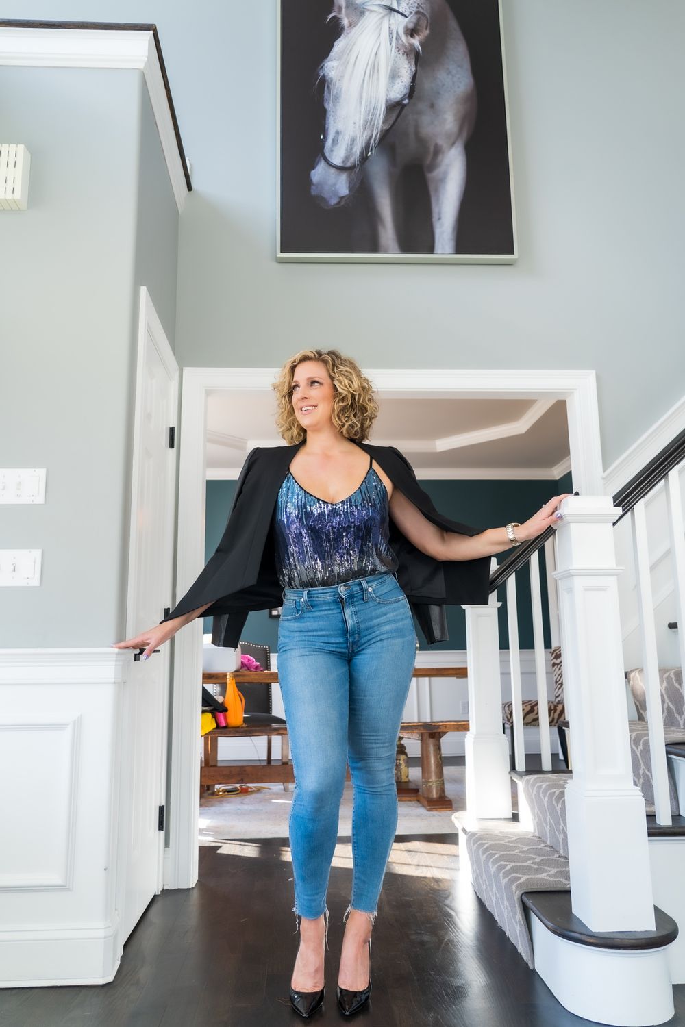 Fashion pose in modern home interior with black and white horse artwork.