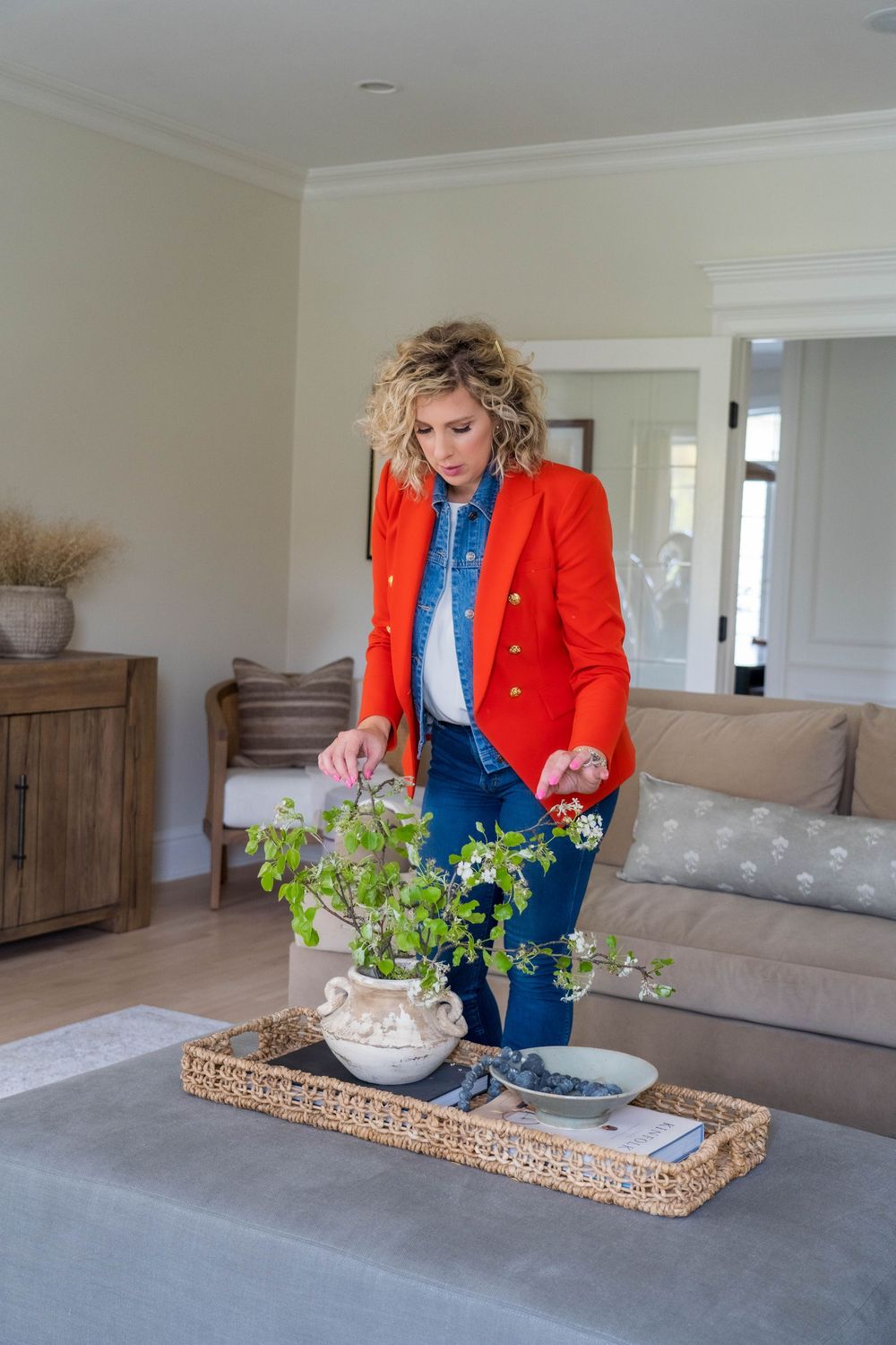 Styling home decor with plants on woven tray in modern living room.