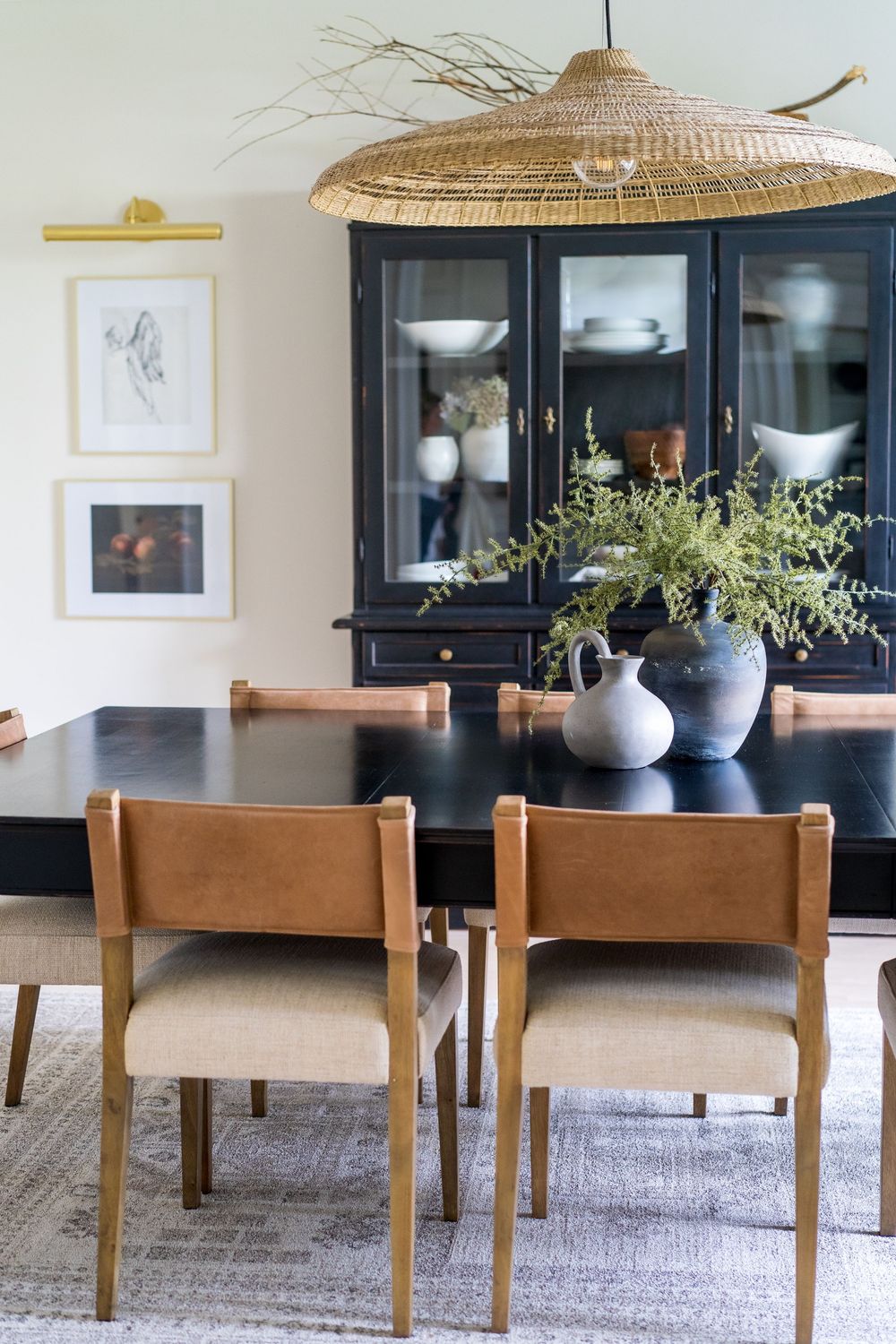 Modern dining room with wooden chairs and woven pendant light over table.