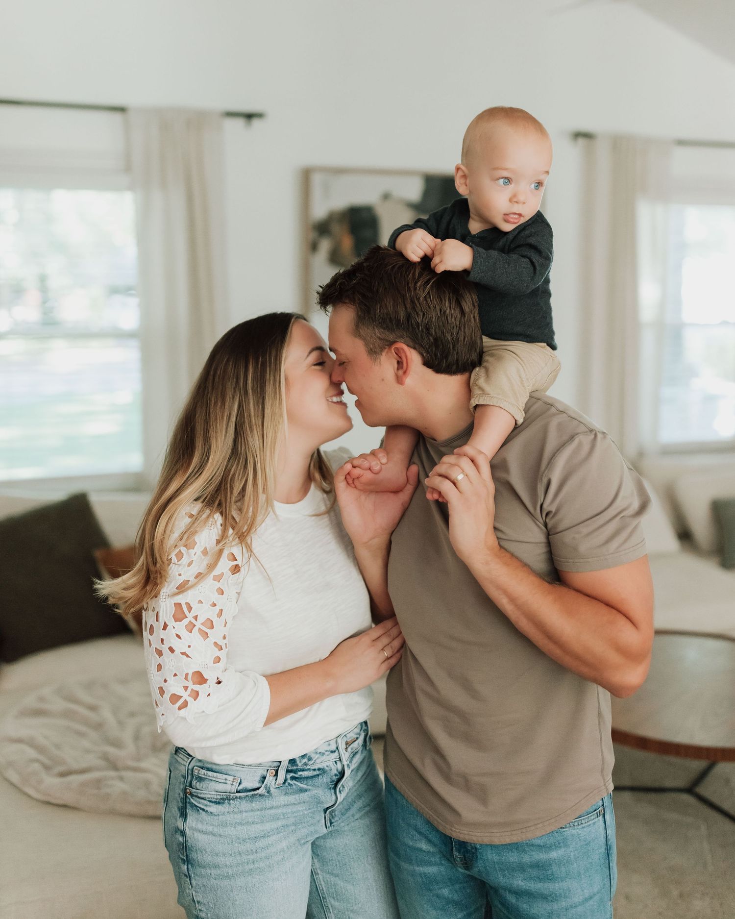 Family sharing loving playful moments together in a bright modern home setting, dressed casually in jeans and tees.