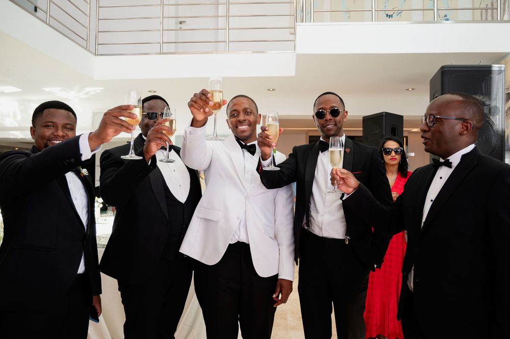 Wedding party in formal attire poses together in a series of fun candid black and white group photos.