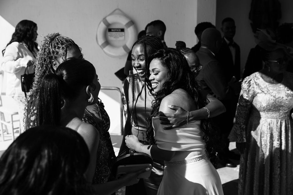 Wedding guests dancing and celebrating on a dance floor in a black and white candid moment.