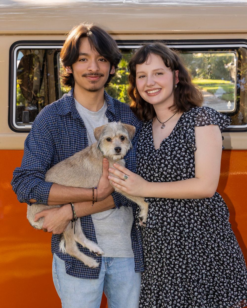 Happy couple with their dog in front of VW Van