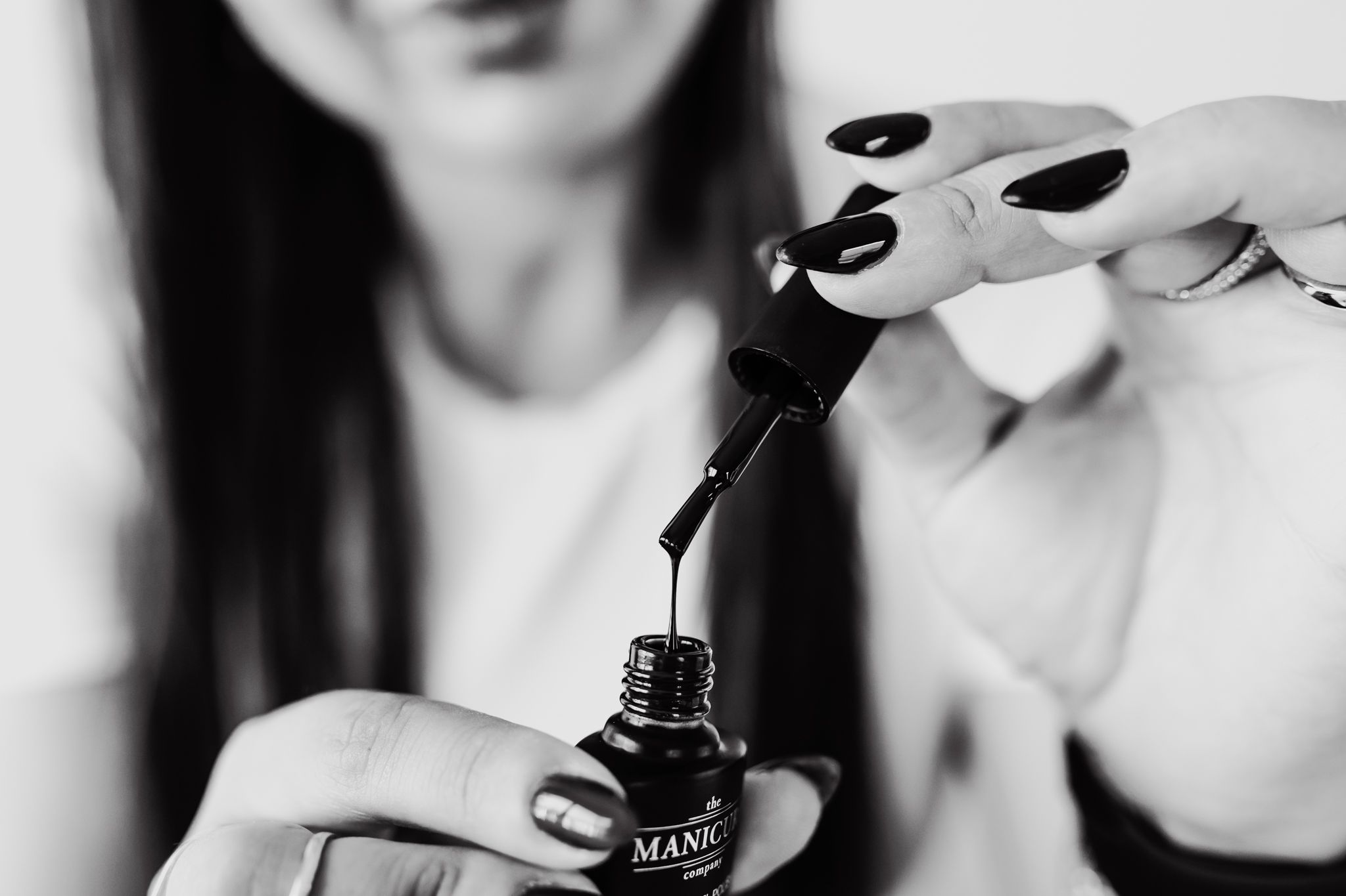 Two hands open a nail polish product.