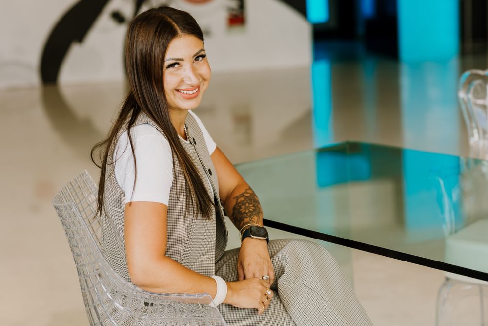 Business woman is sitting near a table in a personal brand photoshoot.